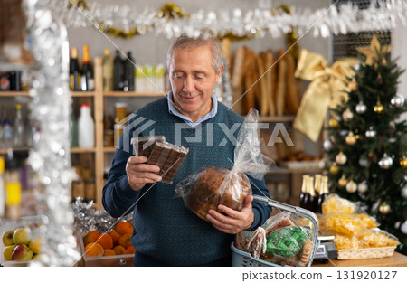 Portrait of mature man buying chocolate and chocolate candies for gift and celebrating Christmas Portrait of mature man buying chocolate and chocolate candies for gift and celebrating Christmas 131920127