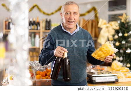 Mature man buys bottles of beer and crisps to celebrate Christmas 131920128