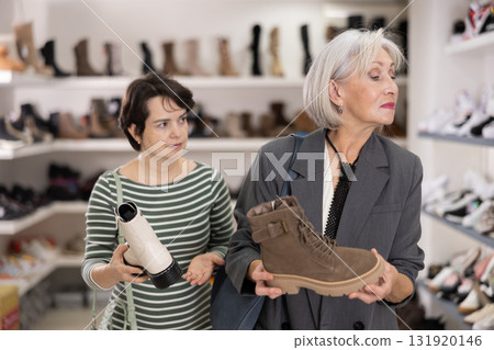 Two women are shopping in shoe store Two women are shopping in shoe store 131920146