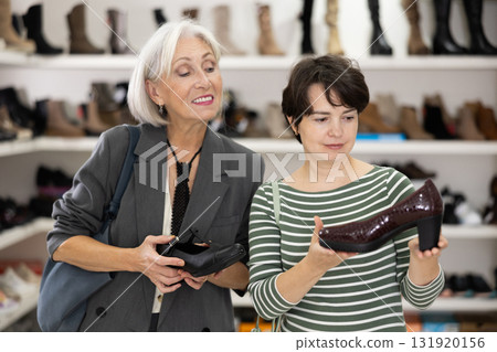 Two women are shopping in shoe store, choose woman dress shoes, classic shoes 131920156