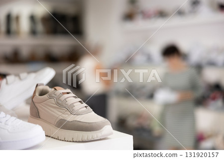 There are sneakers and sports shoes on shelf in store 131920157