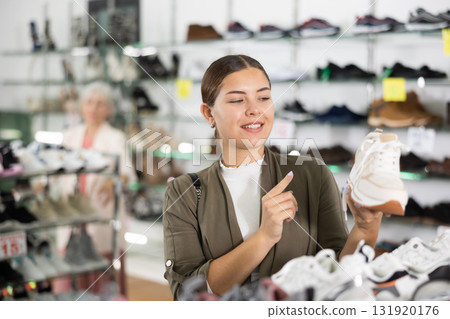 Footwear shop happy girl posing with different shoes Footwear shop happy girl posing with different shoes 131920176