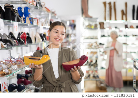 Young woman chooses ballet flats in shoe store 131920181