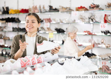 In multi-brand leather goods store,girl chooses modern comfortable running sneakers for fitness In multi-brand leather goods store,girl chooses modern comfortable running sneakers for fitness 131920200