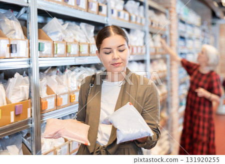 Young woman chooses pack of dry clay 131920255