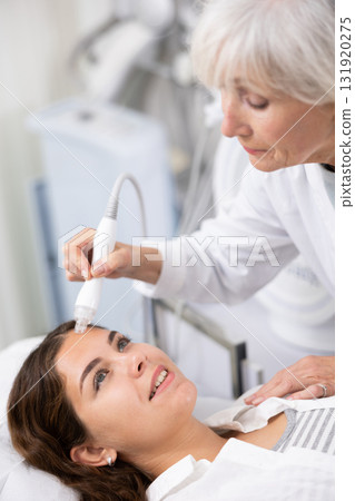 Young woman having face vacuum cleaning procedure 131920275