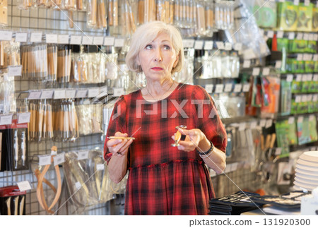 Elderly woman chooses tools for making sculpture Elderly woman chooses tools for making sculpture 131920300