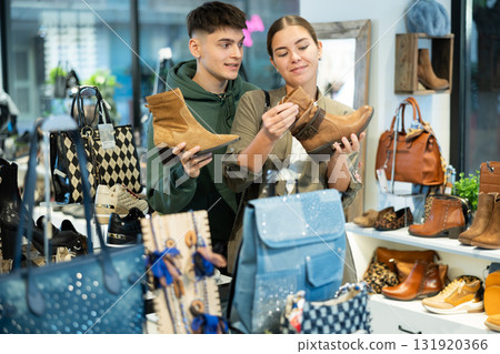 Couple man and woman choosing ankle boots in store 131920366