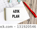 The notebook that says "Planning 401k". Next to the pen and financial statements 131920546