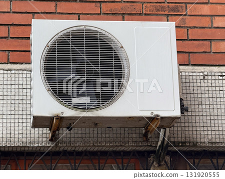 Outdoor air conditioner unit on a brick wall. Urban infrastructure, ventilation system and energy technology representing climate control and industrial design. 131920555