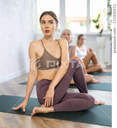 Mom, grandma and teen daughter do simplified pose lord of fish Ardha Matsyedrasana Mom, grandma and teen daughter do simplified pose lord of fish Ardha Matsyedrasana 131920571