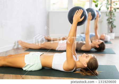 Sporty teen girl training with bender ball at gym 131920600