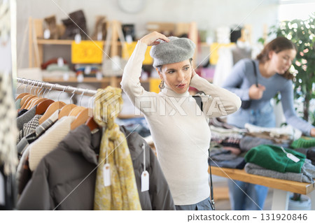Middle-aged woman choosing hat in clothing store 131920846