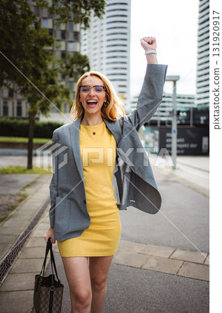 Businesswoman celebrating achievement with fist pump in city street 131920917