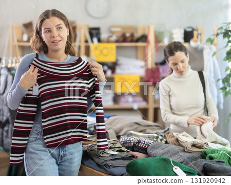 Young woman choosing sweater in clothing store Young woman choosing sweater in clothing store 131920942