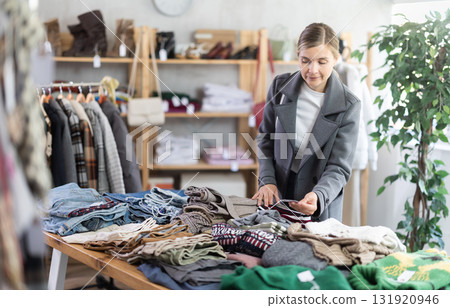European woman browsing goods items and choose elect jumper for autumn European woman browsing goods items and choose elect jumper for autumn 131920946