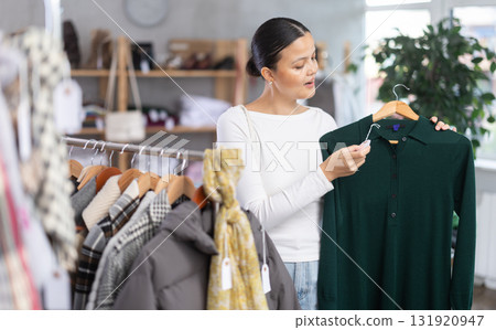 Asian woman browsing goods items and choose elect dress for autumn 131920947