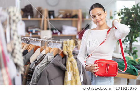 Adult woman choosing handbag in clothing store Adult woman choosing handbag in clothing store 131920950