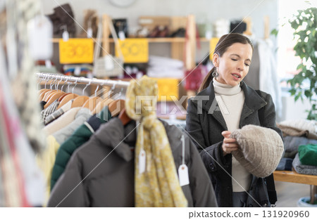 Adult woman choosing hat in clothing store 131920960