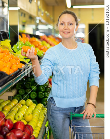woman buys juicy tangerines in supermarket woman buys juicy tangerines in supermarket 131921016
