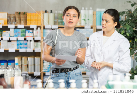 Portrait of asian woman pharmacist helping female client looking for something or choosing prescription drugs at pharmacy shop Portrait of asian woman pharmacist helping female client looking for something or choosing prescription drugs at pharmacy shop 131921046