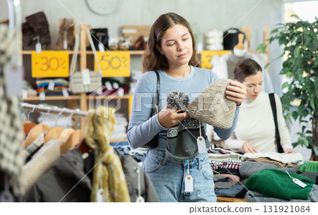 Young girl choosing hat in clothing store Young girl choosing hat in clothing store 131921084