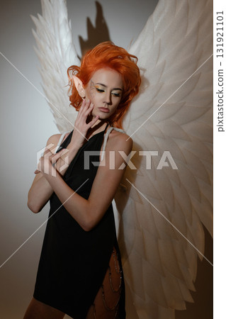 Beauty woman poses topless with angel wings in a creative studio setting Beauty woman poses topless with angel wings in a creative studio setting 131921101