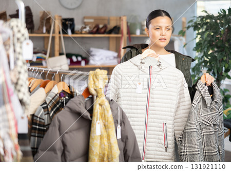 Elegance asian young woman choose something for autumn-winter season in clothing boutique Elegance asian young woman choose something for autumn-winter season in clothing boutique 131921110