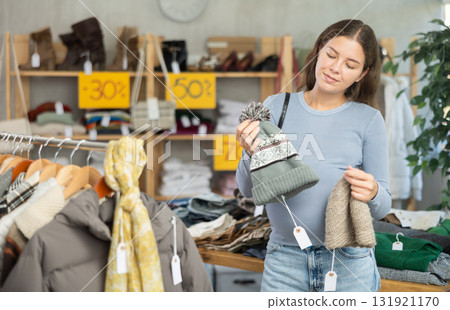 Pregnant woman choosing hat in clothing store Pregnant woman choosing hat in clothing store 131921170