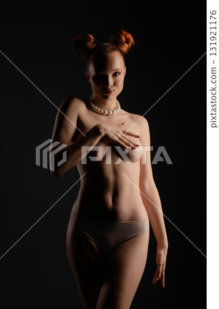 Studio beauty shot of a woman in a creative topless pose Studio beauty shot of a woman in a creative topless pose 131921176