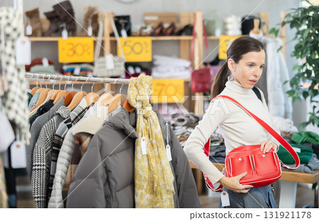 Adult woman choosing handbag in clothing store 131921178