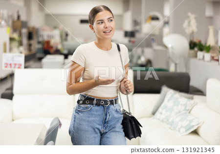 Girls eyes scan room furniture store, searching for perfect item to complete living space Girls eyes scan room furniture store, searching for perfect item to complete living space 131921345