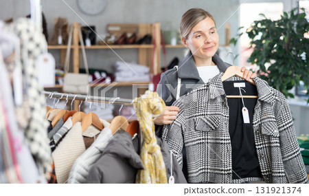 European woman near showcase pick out and buying plaid jacket coat 131921374