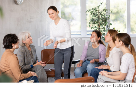 Female teacher giving lecture to group of students in classroom Female teacher giving lecture to group of students in classroom 131921512