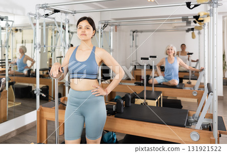Smiling young asian woman standing in pilates studio 131921522