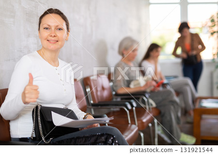 Adult woman with documents waiting for her turn on chair 131921544