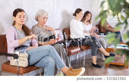 Woman sits on chair while waiting for reception in company office 131921562