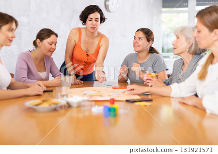 Young female moderator throws stones and determines order of parties in board game Young female moderator throws stones and determines order of parties in board game 131921571