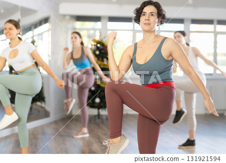Slender young women dancers dance a twist in a modern way during Christmas celebration 131921594