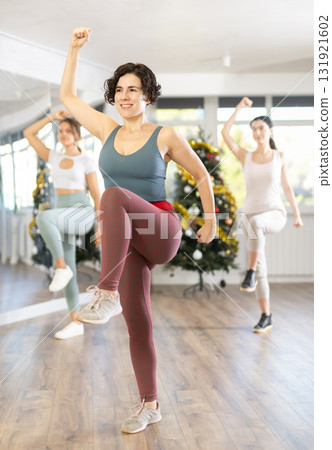 Slender young women dancers dance a twist in a modern way during Christmas celebration 131921602