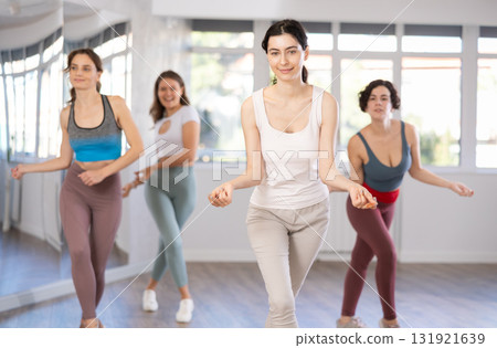 Young female teacher conducts modern hip hop dance lessons for group of girls 131921639