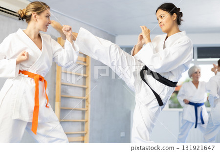 Asian woman in kimono working on kicks and blocks in training bout 131921647