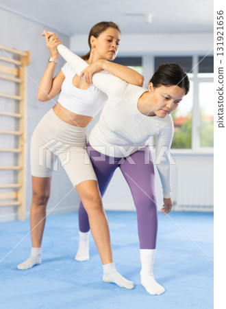 Girl and woman train of performing protection with wring hands during training in self-defense Girl and woman train of performing protection with wring hands during training in self-defense 131921656