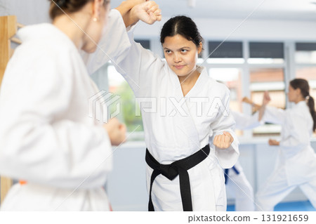 Group of women of different ages practicing punches during karate classes in gym 131921659