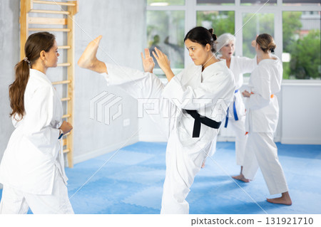 Two women trained to perform basic defensive karate installations and attacking combat techniques 131921710