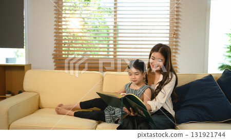 Parent and daughter enjoying storytelling time at home Parent and daughter enjoying storytelling time at home 131921744