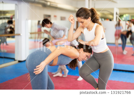 Self-defense training - women practice doing painful holds 131921766