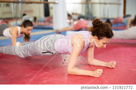 Group exercise in gym - women doing plank exercise 131921772