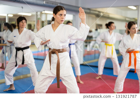 Group of womens practicing martial arts in gym. Active lifestyle and self defense concept Group of womens practicing martial arts in gym. Active lifestyle and self defense concept 131921787