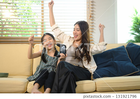 Excited mom and child cheering with joy after winning video game 131921796